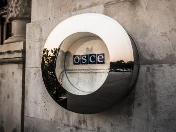 The OSCE logo next to the main gate outside of the Hofburg, Vienna.